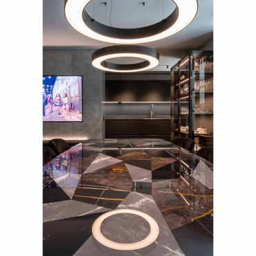 Dining area with stone table and illuminated suspended lamps