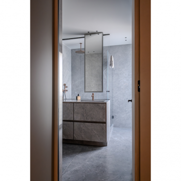 View of the bathroom entrance with continuity between clad walls and glass