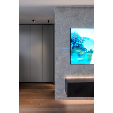 Detail of the TV wall with integrated lighting and textured finish
